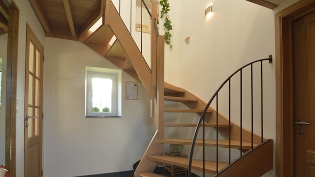 A wooden staircase with a black metal railing, a small window with a view, and a door with a wooden frame. - Countryside Holiday Home in Theux With Fenced Garden and BBQ (Theux)
