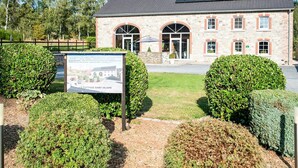 A stone building with a tiled roof, two arched doorways, and a solar panel on the roof. - Liege Villa Near Spa Circuit (Malmedy)