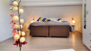 A bedroom with a bed, bedside tables, and a vase with flowers. - Wheelchair-friendly House With Sauna (Buetgenbach)