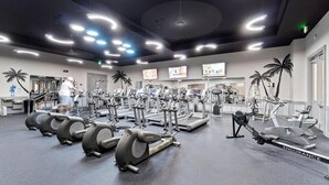 Un gimnasio con varias máquinas de ejercicio, incluyendo cintas de correr y elípticas.