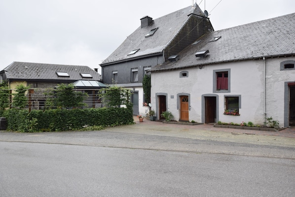 A residential street with houses featuring pitched roofs, dormer windows, and small front gardens.