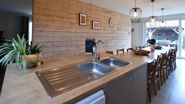 A modern kitchen with wooden paneling, stainless steel sinks, and pendant lighting. - Wonderful Country House With Huge Garden (Poperinge)