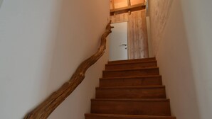 A wooden staircase with a natural wood handrail leading to a white door. - Wonderful Country House With Huge Garden (Poperinge)