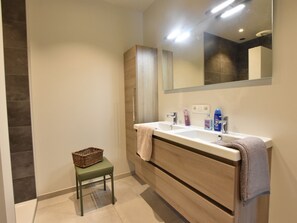A modern bathroom with a double sink, a large mirror, and a small stool with a basket. - Tasteful Holiday Home in Sijsele-brugge With Garden (Damme)