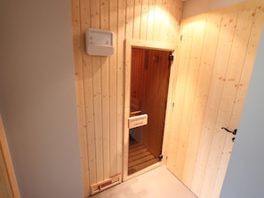 A wooden sauna room with a sign indicating its purpose.