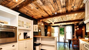 A kitchen with white cabinetry, a stainless steel oven, a trash can, and a wooden ceiling. - Magnificent Holiday Home in Baronville With Heated Pool & Billiards (Beauraing)