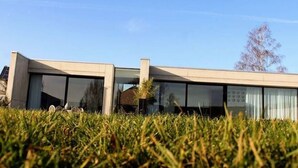A modern two-story building with large windows and a flat roof. - Modern Villa Stay in Dalhem (Dalhem)