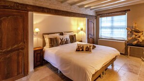 A spacious bedroom with a large bed, wooden headboard, and a window with blinds. - Aesthetic Coastal Villa in Koksijde (Koksijde)