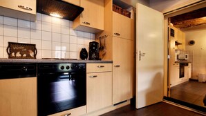 Una cuina moderna amb armaris de fusta, forn integrat i microones.