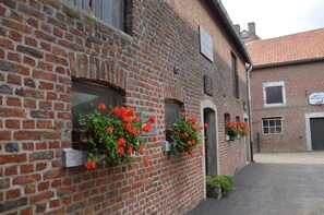 A brick building with multiple windows and flower boxes.
