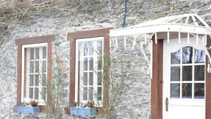 A stone building with two windows and a door, each with wooden frames and white trim. - Holiday Home in Bievre Near Town Center (Bievre)