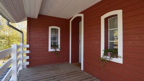 A red wooden porch with white railings and two windows with plants. - Charming Fens Family Home (Waimes)