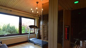 A modern interior with a treadmill, large windows, and a wooden ceiling. - Elegant Villa in Stavelot With Fitness and Playroom and an Incredible Garden (Stavelot)