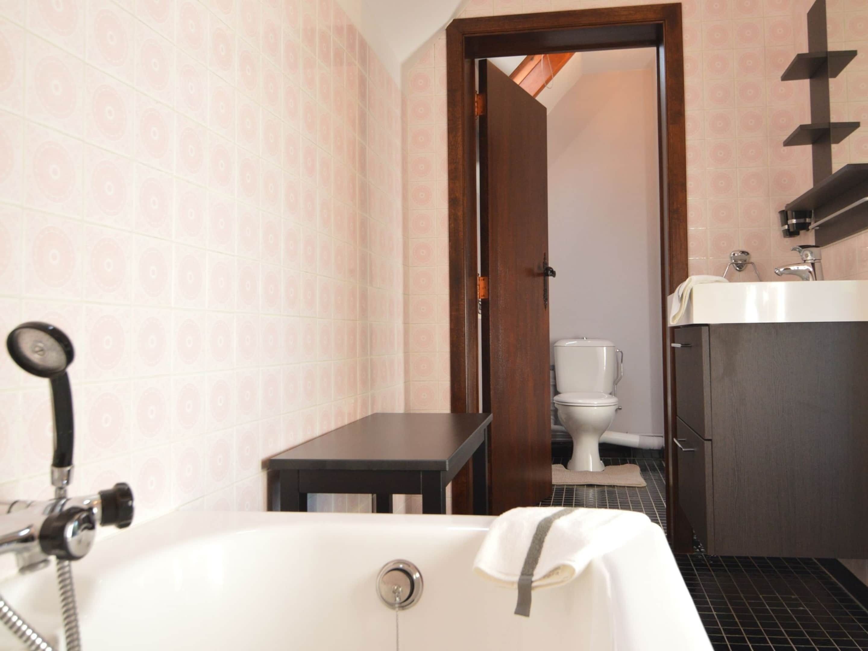 A bathroom with a bathtub, a toilet, a sink, and a shower.