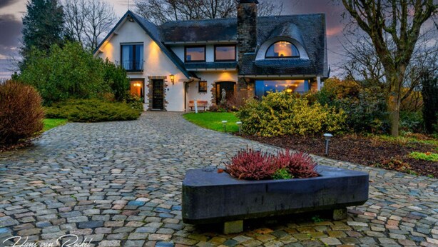 A two-story house with a stone pathway leading to the entrance, surrounded by well-maintained bushes and trees. - Elegant Villa in Stavelot With Fitness and Playroom and an Incredible Garden (Stavelot)