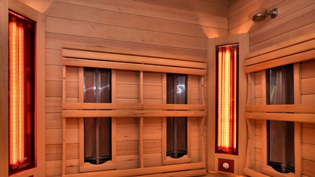 Un sauna avec des murs et des bancs en bois.