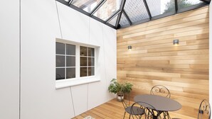 A modern room with a wooden wall, a window, and a table with chairs. - Modern House With Private Pool in Aubel (Aubel)