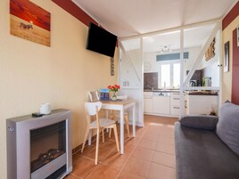 Un espacio habitable pequeño con kitchenette, comedor y sofá.