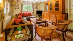 A cozy living room with a sofa, a wooden coffee table, wicker chairs, and a wooden cabinet. - Chalet With Sauna Near Durbuy (Durbuy)