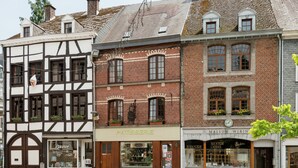 A street view with a patisserie, a boutique, and a traditional building with a clock. - Great Spacious Holiday Home in a Tranquil Holiday (Stavelot)