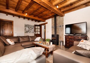 A cozy living room with a sofa set, a television, a fireplace, and a wooden ceiling. - Forest-edge Stay, Burtonville (Vielsalm)