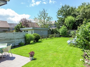 A well-maintained backyard with a patio area, a small shed, and a wooden fence. - Holiday Home in Bredene, Terrace, Fenced Garden (Bredene)