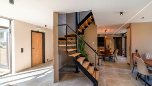 A modern interior with a spiral staircase, a dining area, and a kitchen. - Luxury Villa in Sourbrodt (Waimes)