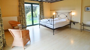 A bedroom with a bed, a chair, a radiator, and a window with curtains. - Scenic Villa Near Lake View (Waimes)