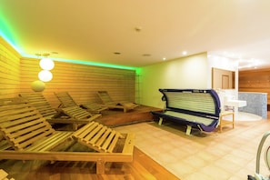 Um quarto com paredes de ripas de madeira, mesa de massagem e sauna.