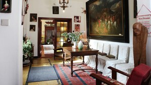 A traditional living room with a large painting, a chandelier, and a red armchair. - Mansion in Ruiselede Doomkerke (Ruiselede)