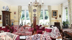 A traditional room with a large window, a chandelier, and multiple pieces of furniture including a sofa and chairs. - Mansion in Ruiselede Doomkerke (Ruiselede)