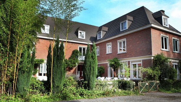 A two-story brick house with a sloped roof, a front porch, and a gated driveway. - Mansion in Ruiselede Doomkerke (Ruiselede)