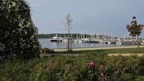 Een jachthaven met veel boten afgemeerd, omringd door groen en een heldere lucht.