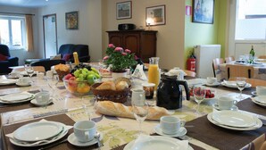 A dining area with a table set for breakfast, including plates, cups, and a variety of food items. - Child Friendly Holiday Home in Waimes with Sauna & Hot Tub (Waimes)