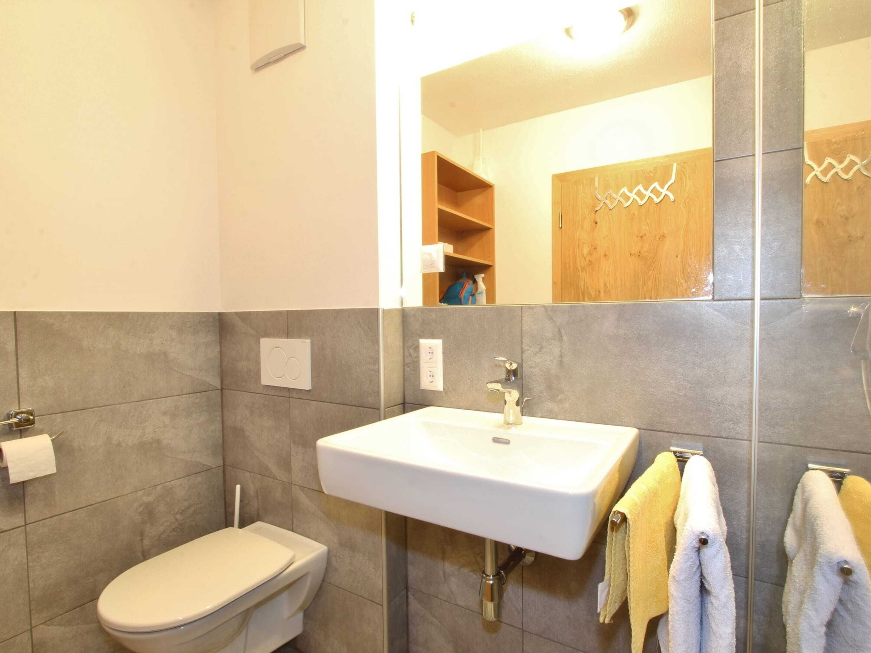 A bathroom with a toilet, sink, and towel rack.