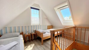 A bedroom with two beds, a window, and a wooden crib. - Endearing Apartment in Insel Poel With Sauna (Insel Poel)