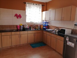 A compact kitchen with wooden cabinets, a sink, a microwave, and a refrigerator.