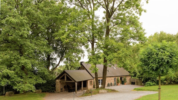 A rustic stone building with a gravel driveway and a fenced area. - Glorious Holiday Home in Wéris with Hot Tub (Durbuy)