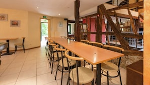 A long wooden table with chairs, a staircase, and a door leading outside. - Glorious Holiday Home in Wéris with Hot Tub (Durbuy)