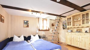 A bedroom with a bed, a wooden wardrobe, a cat tree, and a window. - Sleep Under a Thatched Roof - Apartment in Ahlbeck near Haff (Ahlbeck)
