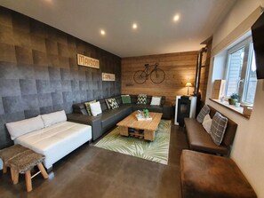 A modern living room with a sofa, a coffee table, and a fireplace.