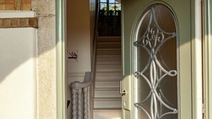 A staircase leading to a door with a decorative metal grille.