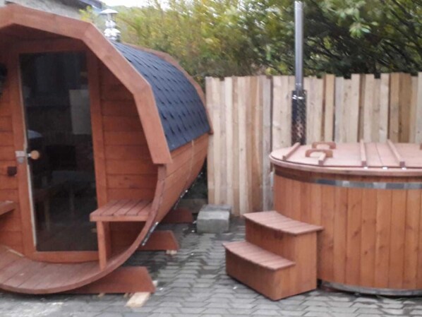 A wooden hot tub with a bench and steps, surrounded by a wooden fence and trees. - Ardennes Stay for 21 Guests (Stavelot)