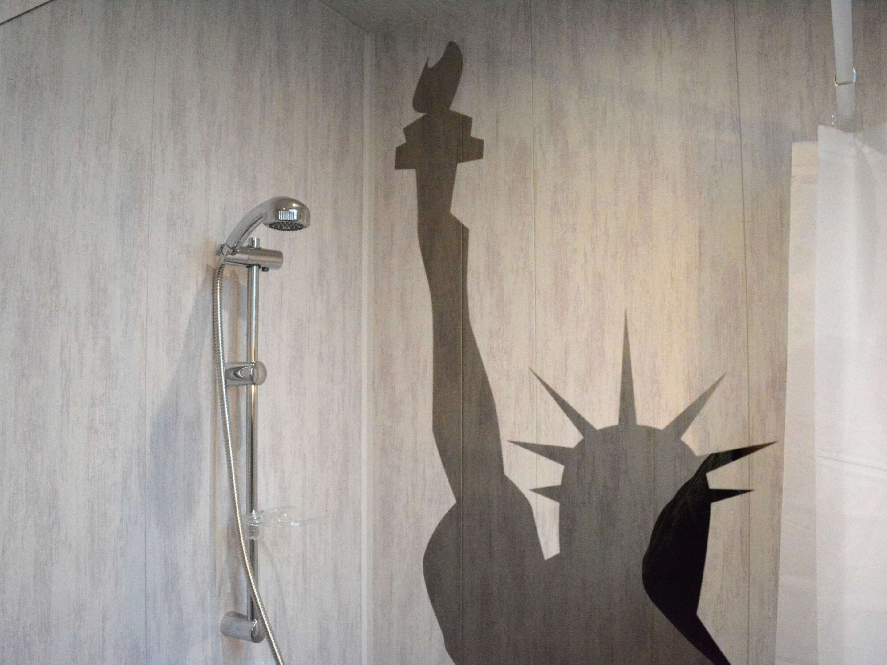 A shower with a faucet and a wall-mounted showerhead.