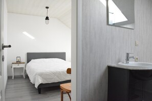 A bedroom with a bed, bedside table, and a small table with a chair. - Railway Stay in Ardennes (Beauraing)