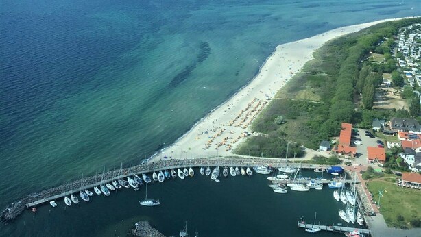 An aerial view of a coastal area with a marina, beach, and residential buildings. - Flat on the Island of Poel With Sauna (Insel Poel)