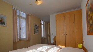 A bedroom with a large bed, wooden wardrobe, and a painting on the wall. - Classy Holiday Home in Rzig near Forest (Uerzig)