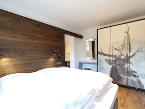 Relax in a serene space with a large bed, framed artwork, and a stylish seating area.