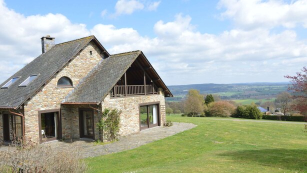 A stone house with a sloped roof, a balcony, and a view of the countryside. - Hillside Retreat With Pond (Lierneux)