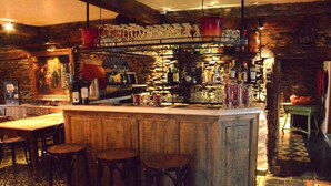 Eine Bar mit Hockern, einer Theke und verschiedenen Flaschen und Gläsern.